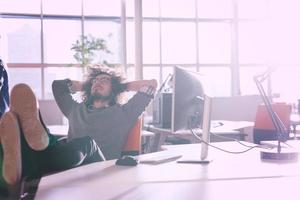 homme d'affaires assis avec les jambes sur le bureau photo