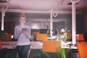 femme travaillant sur tablette numérique au bureau de nuit photo