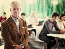 portrait d'un enseignant en classe avec un groupe d'étudiants en arrière-plan photo