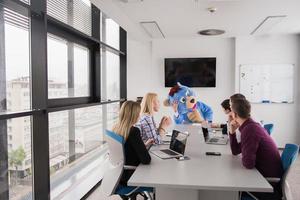 patron habillé en ours s'amusant avec des gens d'affaires dans un bureau branché photo