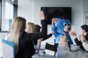 patron habillé en ours s'amusant avec des gens d'affaires dans un bureau branché photo