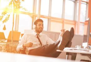 jeune homme d'affaires détendu d'abord sur le lieu de travail tôt le matin photo