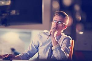 homme travaillant sur ordinateur dans un bureau sombre photo