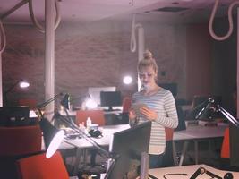 femme travaillant sur tablette numérique au bureau de nuit photo