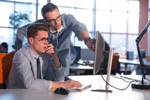 deux hommes d'affaires travaillant avec un ordinateur au bureau photo