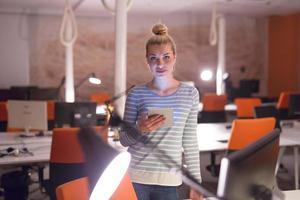 femme travaillant sur tablette numérique au bureau de nuit photo