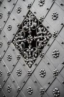 Ancienne porte en fer richement décorée avec grille photo