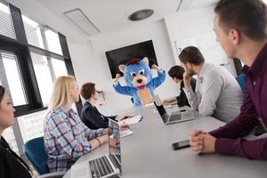 patron habillé en ours s'amusant avec des gens d'affaires dans un bureau branché photo