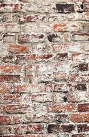 Vieux mur de briques minables blanchies à la chaux inégales pourries