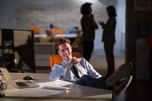 homme d'affaires assis avec les jambes sur le bureau au bureau photo