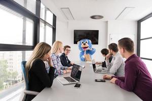 patron habillé en ours s'amusant avec des gens d'affaires dans un bureau branché photo