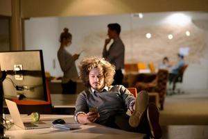 homme d'affaires assis avec les jambes sur le bureau au bureau photo