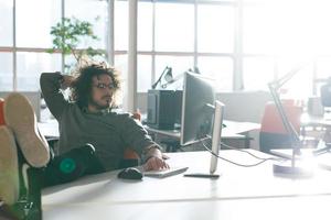 homme d'affaires assis avec les jambes sur le bureau photo