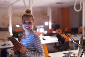 femme travaillant sur tablette numérique au bureau de nuit photo