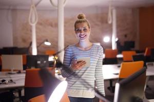 femme travaillant sur tablette numérique au bureau de nuit photo