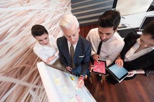 groupe de gens d'affaires remue-méninges et prise de notes sur le tableau de bord photo