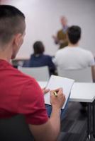 étudiant de sexe masculin prenant des notes en classe photo