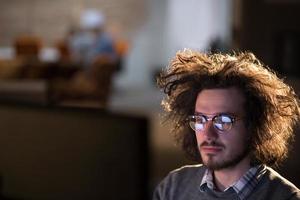 homme travaillant sur ordinateur dans un bureau sombre photo