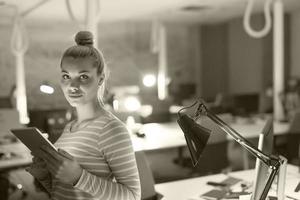 femme travaillant sur tablette numérique au bureau de nuit photo