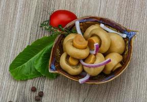 Champignon mariné dans un bol sur fond de bois photo