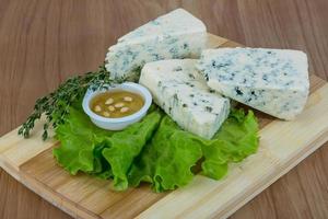 Fromage bleu sur planche de bois et fond de bois photo