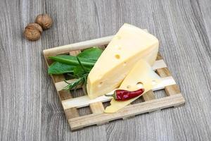 Fromage jaune sur planche de bois et fond de bois photo