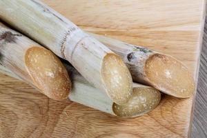 bâtonnets de sucre sur planche de bois et fond en bois photo