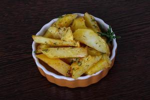 pomme de terre rôtie dans un bol sur fond de bois photo