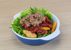 Salade de thon dans un bol sur fond de bois photo