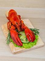 Homard bouilli sur planche de bois et fond de bois photo