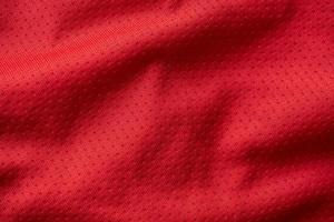 maillot de football de vêtements de sport en tissu rouge avec fond de texture en maille d'air photo