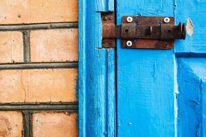 Loquet métallique fermé sur porte en bois peinte en bleu photo