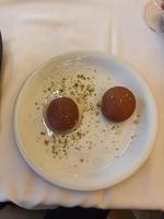 l'un des desserts en dinde, le gulab jamun, qui est servi jusqu'à deux morceaux sur une assiette blanche. photo