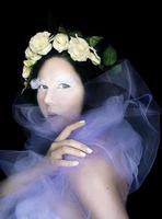 portrait conceptuel d'une femme étrange dans une couronne de roses blanches avec un maquillage fantastique pour da de muertos photo