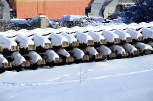 beaucoup de vieux rails et traverses sont empilés dans un entrepôt ferroviaire en hiver. le concept de renouvellement d'une voie ferrée usée photo