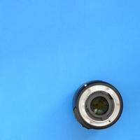 une lentille photographique se trouve sur un fond bleu vif. espace pour le texte photo