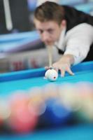 jeune homme joue au jeu de billard pro photo