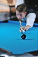 jeune homme joue au jeu de billard pro photo