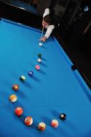 jeune homme joue au jeu de billard pro photo