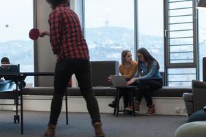 deux femmes d'affaires assises dans un espace de coworking moderne pendant une pause du travail et se détendre à l'aide d'un ordinateur portable. mise au point sélective photo