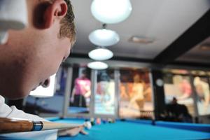 jeune homme joue au jeu de billard pro photo