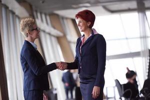 les femmes d'affaires font un accord et une poignée de main photo