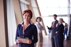 femme d'affaires au bureau avec tablette devant en tant que chef d'équipe photo