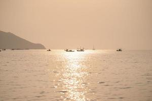 coucher de soleil sur la mer avec sur la plage tropicale et le ciel orange pastel. photo