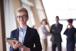 femme d'affaires au bureau avec tablette devant en tant que chef d'équipe photo