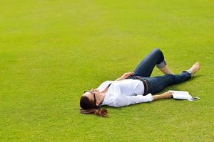 jeune femme lisant un livre dans le parc photo