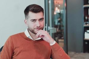 portrait d'heureux propriétaire d'entreprise masculin du millénaire dans un bureau moderne. homme d'affaires, souriant et regardant la caméra. notion de leadership. photo du visage.