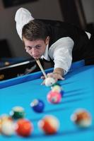 jeune homme joue au jeu de billard pro photo