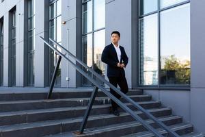 homme d'affaires asiatique monte les escaliers du centre de bureau, l'homme se précipite vers une entreprise photo