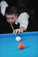 jeune homme joue au jeu de billard pro photo